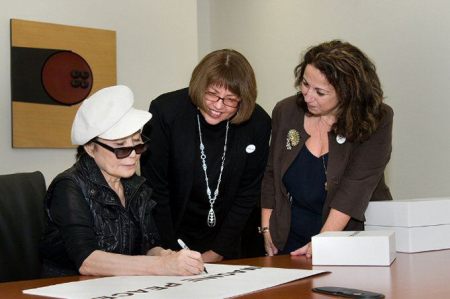 yoko signs posters and catalogues for university officials and everyone else.jpg